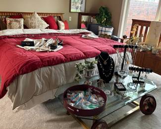 King size bed with comforter. Glass and brass coffee table.