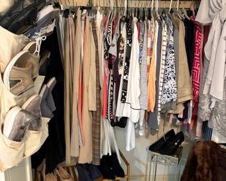 One of several closets loaded with clothing and shoes.