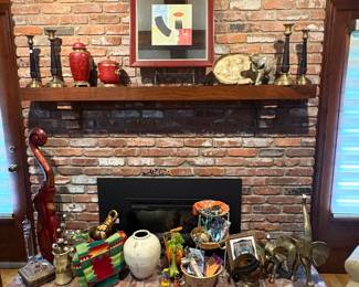The fireplace is holding a variety of interesting baskets, brass elephants, and other fun stuff.