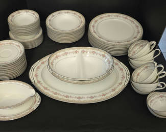 Lot 28: Porcelain dinnerware set with pink floral border and gold trim