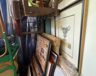 Stacks of framed art, upside down, sideways, on the walls, in the bathrooms