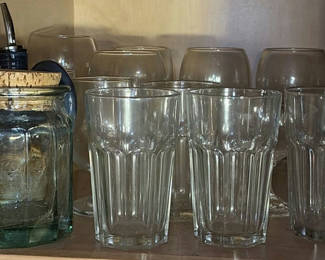 Lot 66: Glassware collection: clear ribbed tumblers, goblets, and a green corked jar