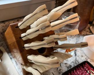Cutco knife set with white handles and wooden storage block.
