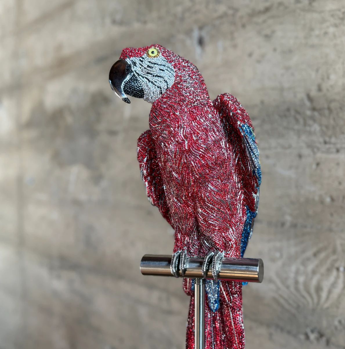 This lot features a stunning Macaw sculpture by listed artist, Jay Strongwater. Dazzling with over 1,000 hand set Swarovski crystals and sits on a plinth. Originally purchased from gallery for $14,000. Comes with additional crystals and repair kit to replace any missing crystals over time. The Macaw measures, 24” H and on the stand measures, 66” H.