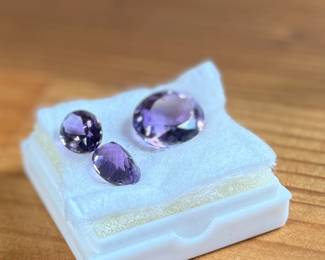 This lot features three (3) Amethyst gemstones with a total carat weight of 30.95. The pair measures 14mm x 10mm and the large stone at 20mm x 16mm.