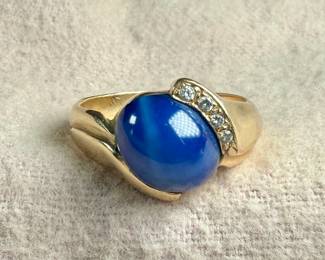 This lot features a beautiful 14k gold ring with a star sapphire center stone and genuine diamonds. Comes in a size 8 with a total approx. weight of 7.26 grams.