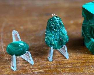 This lot features a collection of beautiful Malachite trinket boxes with lids, a pendant, and a cabochon.