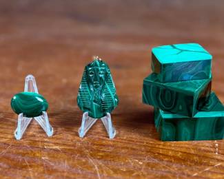 This lot features a collection of beautiful Malachite trinket boxes with lids, a pendant, and a cabochon.