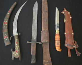 Left to right: Indo-persian knife with inlaid wood sheath; WW1 Canadian Made US Mark 1 bayonet with sheath; vintage Finnish hunting knife with sheath