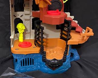 Fisher-Price Imaginext Castle Wizard Tower playset features orange and blue castle walls, a spiral wheel, and a yellow projectile ball