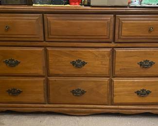 vintage, solid wood dresser featuring brass-colored drawer pulls (missing one knob)