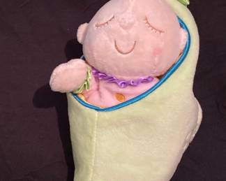 Manhattan Toy Company Sweet Pea Snuggle Pod features a soft, sleepy doll nestled inside a satin-lined green plush pea pod