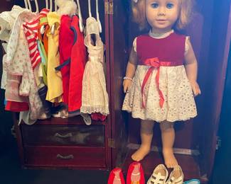vintage 20-inch Mattel Chatty Cathy doll with reddish blonde hair, a red velvet party dress, and a wooden wardrobe filled with various doll clothes and shoes