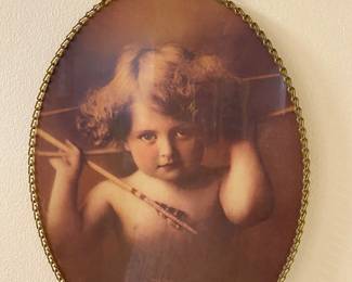 vintage-style 1897 "Cupid Awake" flue cover print by M.B. Parkinson, housed in a glass-covered, oval-shaped chain-framed wall art piece