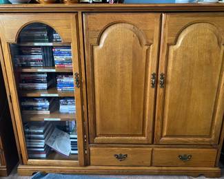 solid oak Thomasville entertainment center features a glass-paneled storage cabinet and lower drawers
