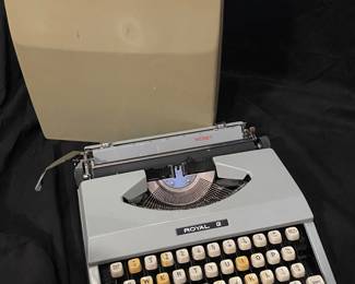 a vintage 1970s Royal Signet manual portable typewriter featuring a grey body and a matching hard case