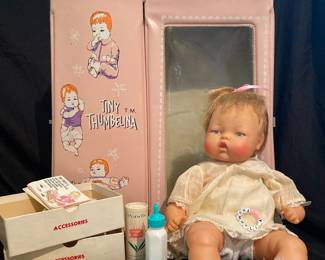 vintage 1960s Ideal Toy Corp "Tiny Thumbelina" doll, featuring her original pink vinyl carrying case and various accessories