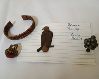 Lot 40: Copper braided bracelet, red cabochon ring, bronze bird pin, and grape cluster ring