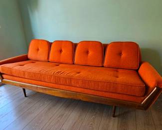 MCM Adrian Pearsall-style Gondola Sofa in Vibrant Textured Orange Fabric with Walnut Wood Accents.