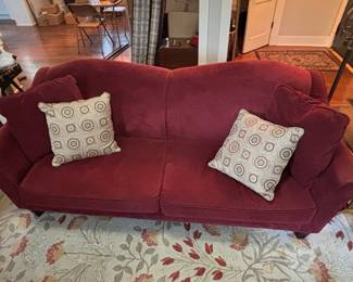 Red Velvet Camelback Sofa with Decorative Pillows
