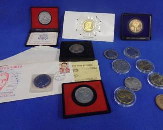 Lot 64. Collectible non-circulating coins, tokens, and more. 3 $10 coins from the Marshall Islands. Three one crown coins with Queen Elizabeth II. One $5.00 Desert Storm coin. One N.A.H.C. medallion. Four America First medallions. One $10 Elvis Presley Marshall Islands coin. Ronald Reagan medallion layered in .999 silver.