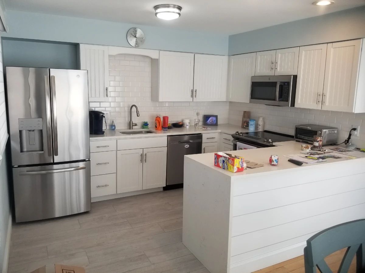Duplex - two identical U-shaped kitchens with white cabinetry & new countertops