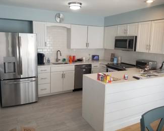 Duplex - two identical U-shaped kitchens with white cabinetry & new countertops
