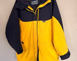 Gill foul weather sailing jacket in yellow/navy with waterproof, windproof construction, fleece-lined collar, and adjustable cuffs—ideal for boating, fishing, or Great Lakes weather.