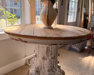 Unique round accent table featuring a rustic wood top and beautifully carved pedestal base with a charming distressed finish.