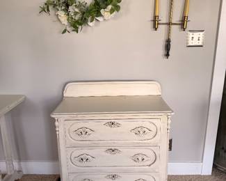 Charming distressed white three-drawer chest with carved details, offering timeless cottage style and versatile storage.