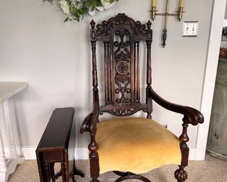 Stately carved wood armchair with upholstered seat accompanied by a classic folding accent table, adding timeless elegance to any room.