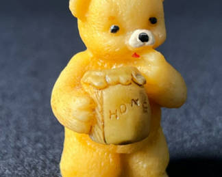 Lot 96: Yellow teddy bear figurine holding a honey jar