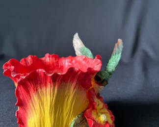 Lot 94: Colorful flower sculpture with hummingbird and cowboy figurine