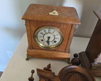 American tambour or "humpback" variant mantel clock made of quarter-sawn oak, manufactured around the 1910s to 1920s.