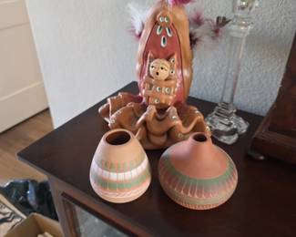 Southwestern Native American-style pottery, including a stylized clay figure and two small seed pots.