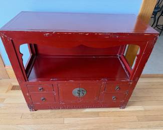 Vintage red lacquer sideboard with an open display shelf over a lower cabinet — paired doors with a brass lock-plate, small flanking drawers, and a carved Greek-key apron. $125