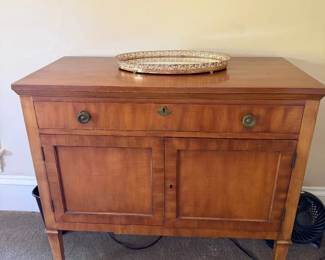 Charming antique sideboard in honey walnut w/ single top drawer over 2 paired panel doors. Oval brass pulls. $150.