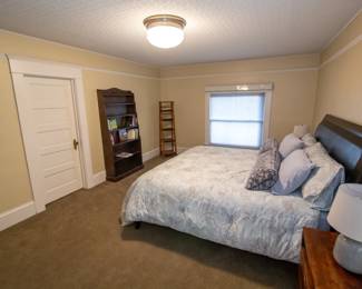 A striking king-size sleigh bed with a rich espresso-brown hardwood frame and a deep leather-paneled headboard. Substantial, elegant, and beautifully made. Paid $1500 for bedframe. Selling for $750. King Mattress top of the line- only slept in approx. 500 nights. $750.