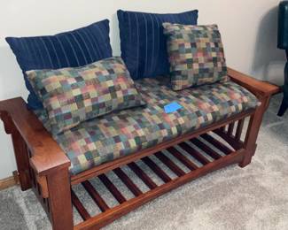 Mission-style wood settee bench with upholstered cushion, coordinating pillows, and lower slatted shelf