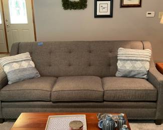 Contemporary three-cushion upholstered sofa with tufted back and nailhead trim