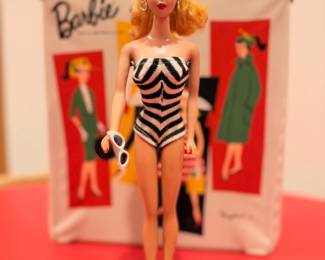Ca. 1961 Barbie with original black & white swim suit, black heels, high pony tail and white w/ blue lense cat eye sunglasses.  She will be sold separately from the Barbie case and other accessories