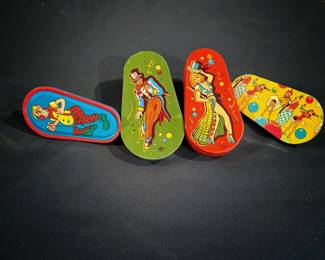 These are vintage tin lithograph party noisemakers featuring colorful circus and celebration graphics, produced by The U.S. Metal Toy Mfg. Co. during the 1940s–1950s.