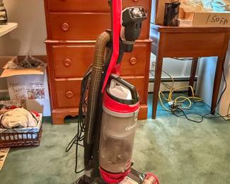This is a red and black Bissell CleanView Upright Vacuum Cleaner featuring a transparent bagless dirt tank and onboard hose attachment.