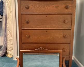 This is a vintage quarter-sawn tiger oak highboy dresser with a detachable swivel mirror and wooden pull knobs, dating from the early 20th century.