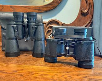 These vintage Porro prism binoculars feature traditional center focus wheels and textured rubberized or pebbled armor body finishes.