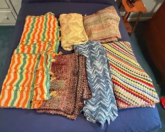 This shows a collection of handmade vintage crochet and knit afghan throw blankets featuring various classic styles, including chevron/ripple patterns and textured stitches.
