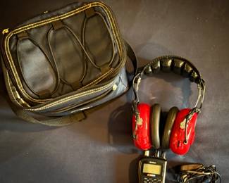 The is a Uniden BC72XLT NASCAR Handheld Scanner Kit complete with red racing headphones, a carrying case, and an AC adapter.