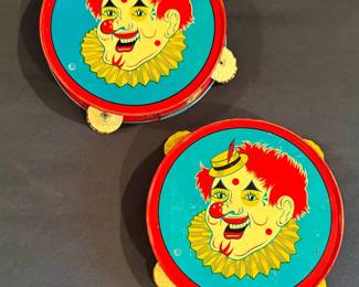 These are vintage mid-20th-century tin litho clown tambourines/noisemakers, produced by The U.S. Metal Toy Manufacturing Co.