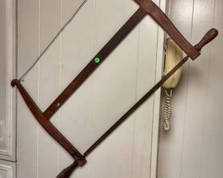 This is an antique wooden frame or bow saw.
