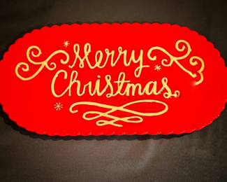 This festive red and gold "Merry Christmas" platter features a scalloped edge, ornate cursive lettering, and delicate snowflake accents.